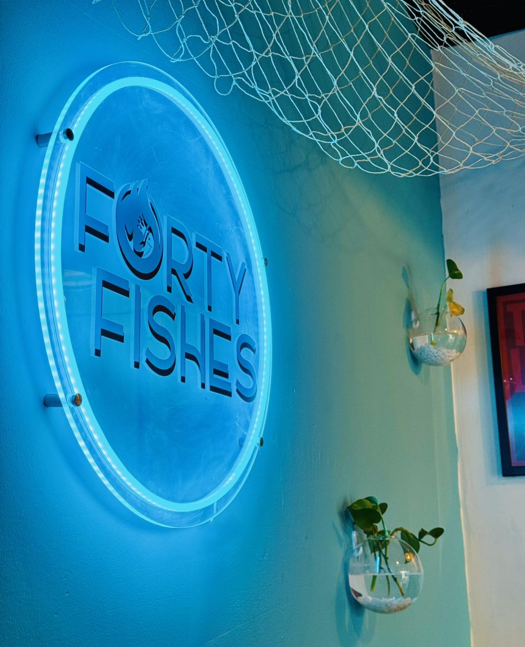 Forty Fishes neon sign glowing blue